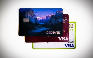  A stack of 3 credit cards including Visa and Mastercard.